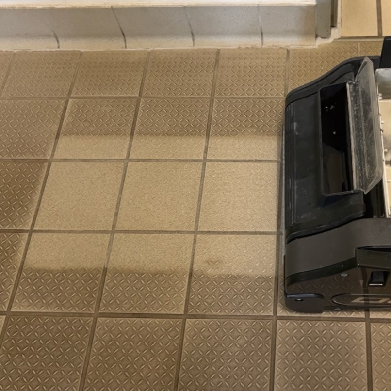 commercial floor machine scrubbing safety tiles in a commercial environment, showing a clear before and after result.